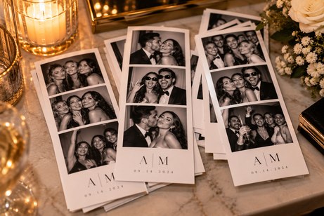 Personalized photo booth strips arranged on a wedding table