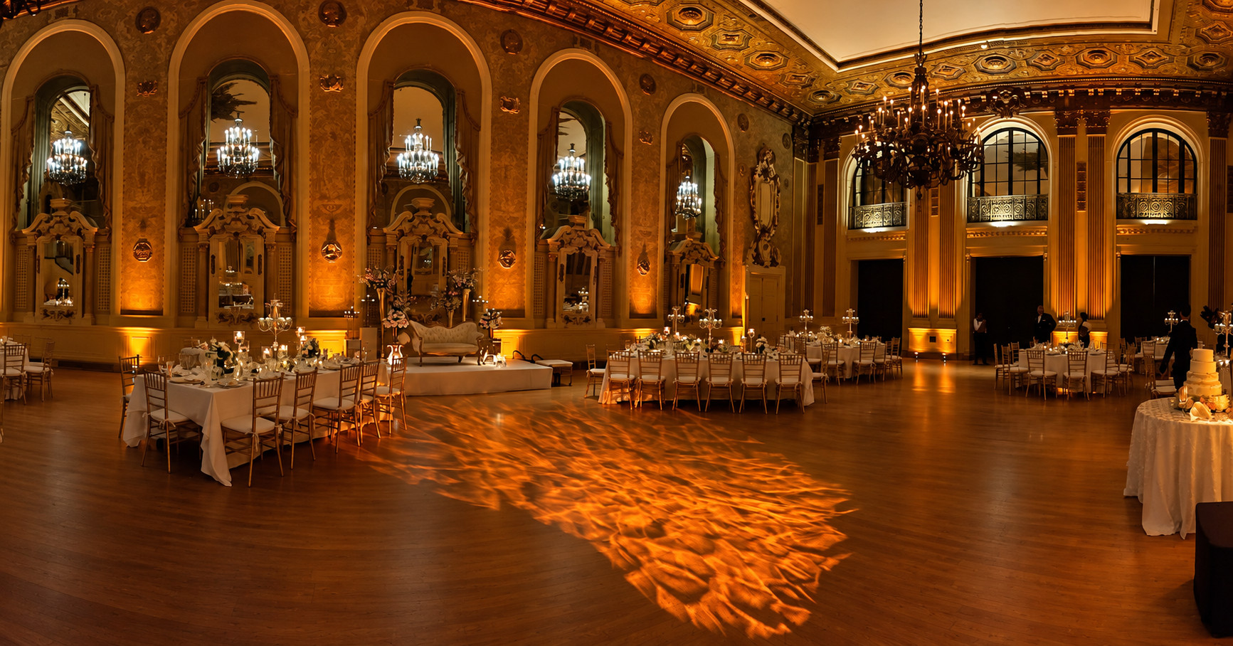 Elegant ballroom lit with warm amber uplighting