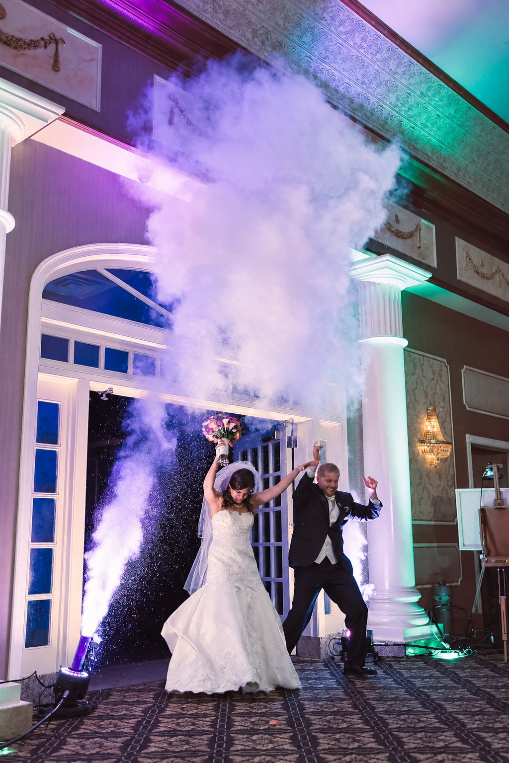 Bride and groom celebrating beneath atmospheric event effects