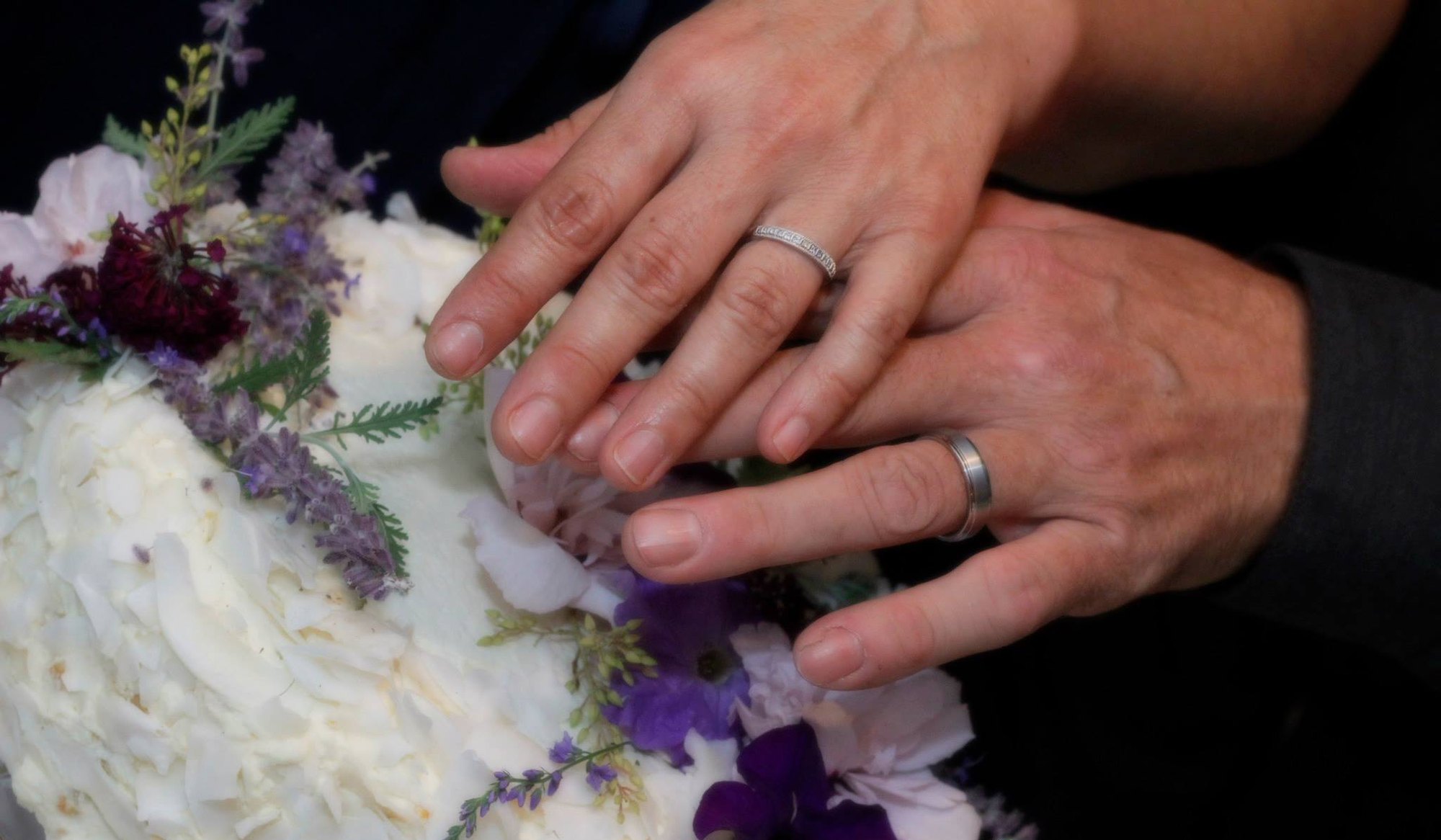 Close-up of a wedding ring beside flowers