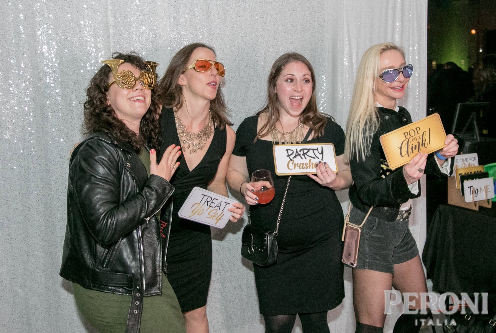 Friends posing together with playful props at a party
