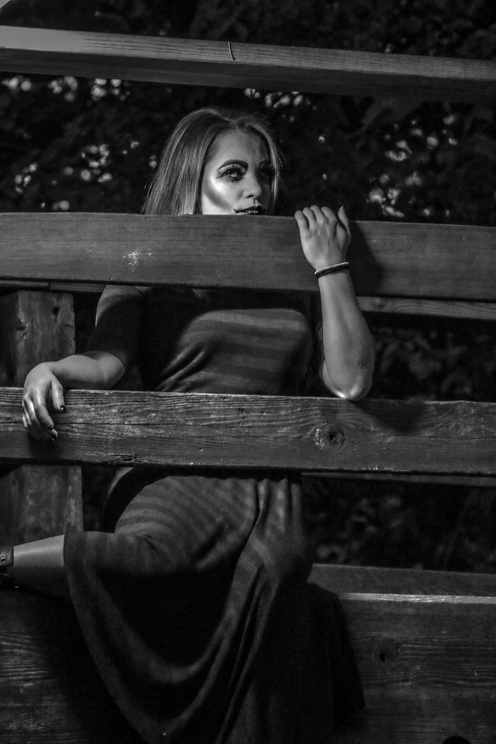 Black and white portrait beside a wooden fence